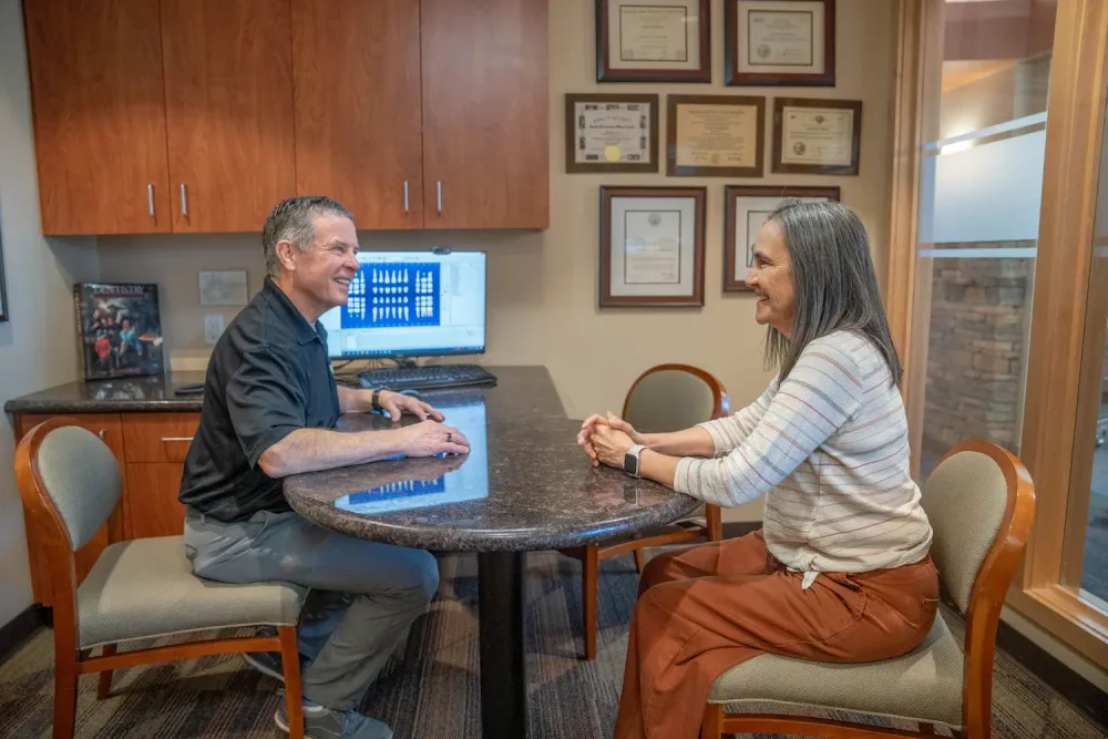 A dentist showing a patient their digital scan on screen